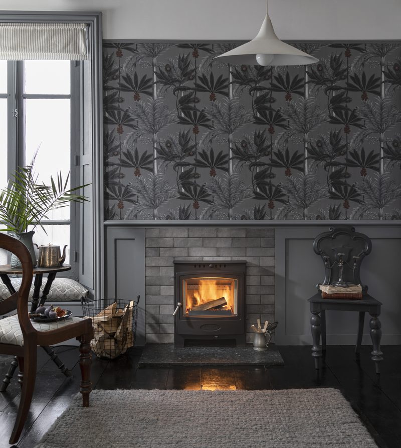 A wood burning stove glowing warmly in a traditional stone-walled living room